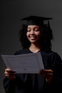 a black female student looking at certificate of graduation