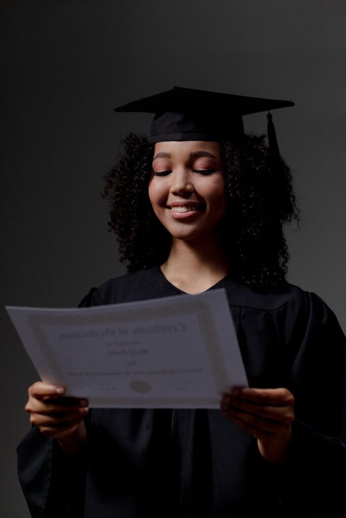 a black female student looking at certificate of graduation